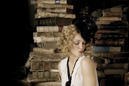 La ragazza con il cappello nero. Ragazza in biblioteca. Libri antichi. Strega
