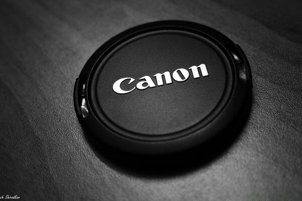 Natura morta con coperchio della fotocamera sul tavolo