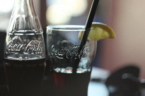 Bottiglia e bicchiere con Coca Cola