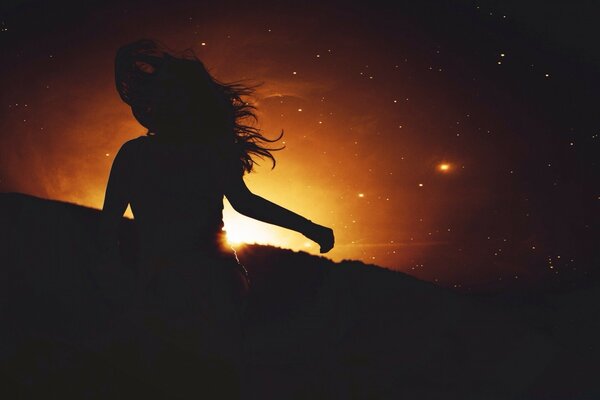 Silhouette scura di una ragazza al tramonto