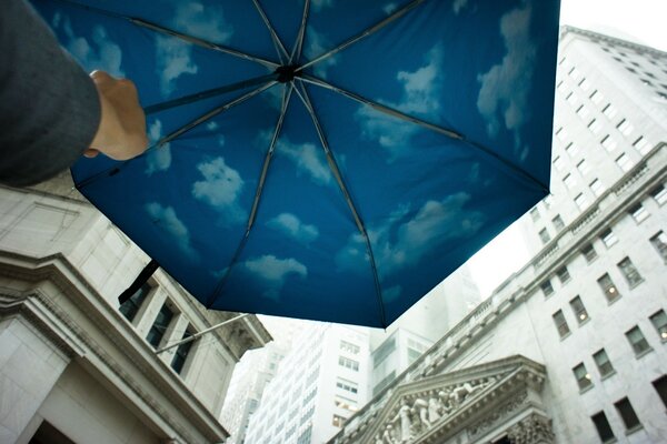 Ombrello blu con nuvole vicino a grandi case
