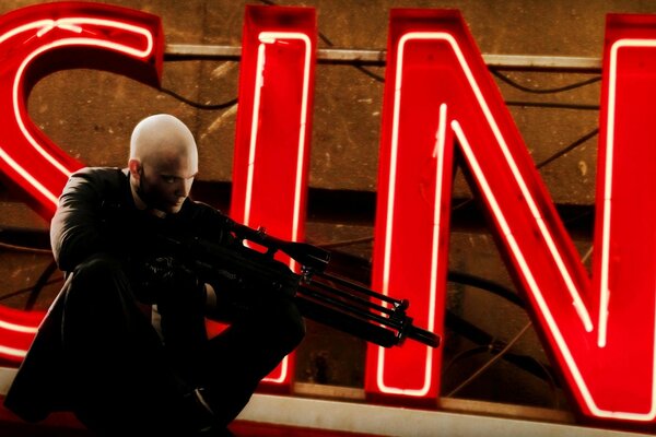 Hitman cerca il bersaglio sullo sfondo della didascalia