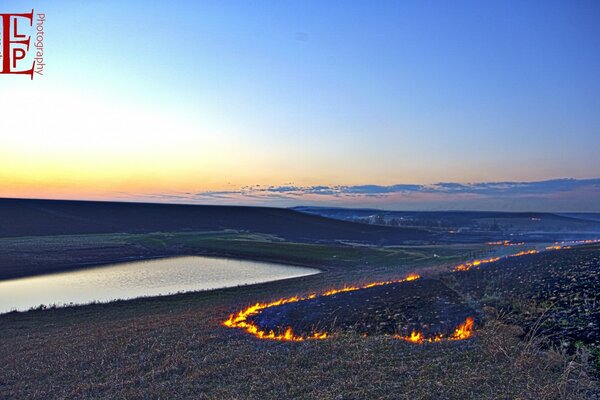 Fuoco, campo, tramonto e fiume